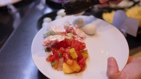 Person Serving Quail Eggs onto a Salad Plate at a Buffet Stock Footage 336649616