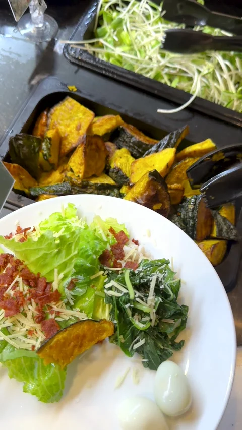 Person Serving Roasted Pumpkin onto Salad Plate at Buffet Bar Stock Footage 335620301