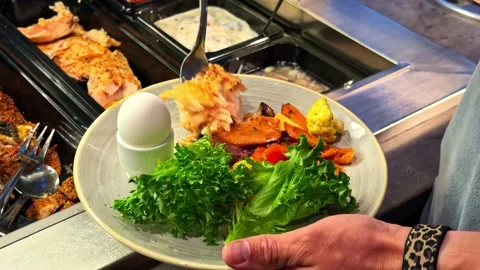 Person Serving Salmon, Vegetables, and Egg at Buffet Counter in Norway Stock-Footage 340254850