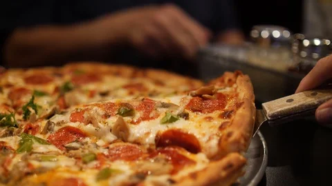 Person serving a slice of pizza with melted cheese Stock-Footage 101220566