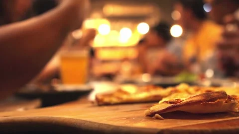 Person serving a slice of pizza on the table. People take slices of delicious Vídeos de archivo 336586733