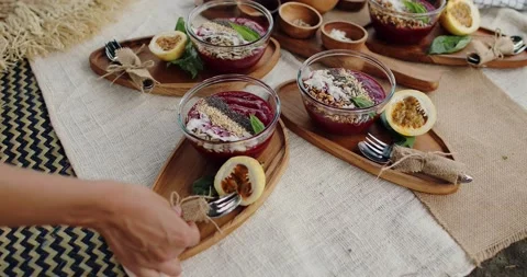 Person sets a table by placing a tableware wrapped in linen on a wooden plate Stock Footage 148003760