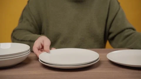 Person setting the table or organizing white porcelain dishes Stock Footage 335209368