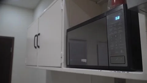 Person setting timer on a modern microwave oven Stock Footage 320968165