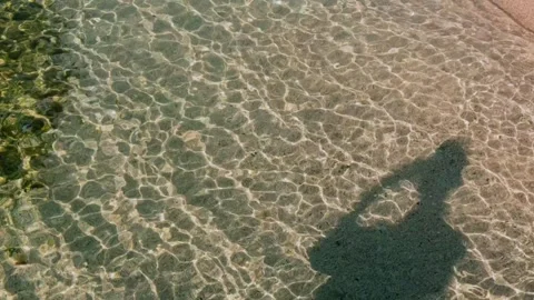 Person Shadow with Smartphone in Clear Shallow Water Stock Footage 333967133