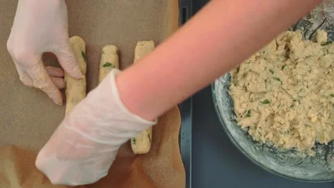 Person shaping and arranging raw sausage logs on baking sheet indoors Stock Footage 342872014