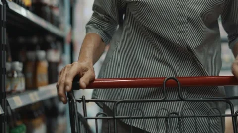 A person is shopping in a store and is pulling a shopping cart Stock Footage 313942477