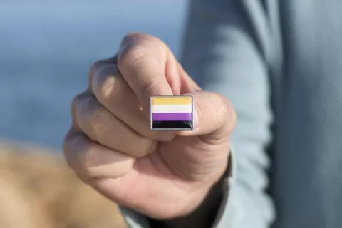 Person showing a non-binary pride flag Stock Photos