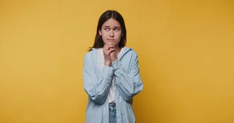 Person shows different emotions while standing against a yellow backdrop in.. Видео 328248193