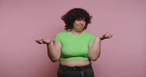 Person shows different expressions with hands raised in a studio against a .. 스톡 동영상 331990749