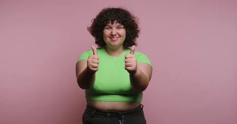 Person shows thumbs up in four different expressions in a studio setting 스톡 동영상 331990675
