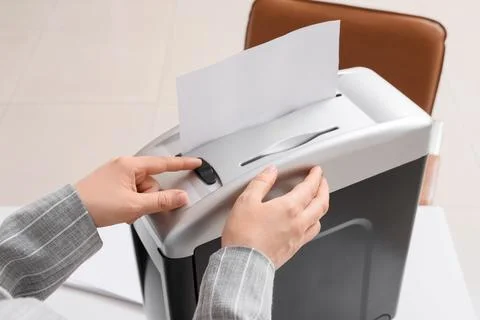 Person shredding confidential documents for data protection and information s Stock Photos