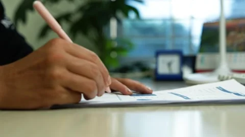 Person signing documents at office desk, Close-up of a person signing or fi.. Stock Footage 345119992