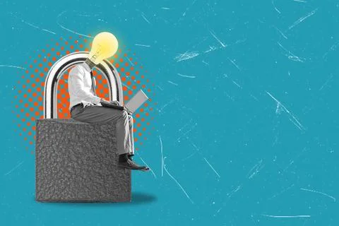 A person sits on an oversized padlock while working on a laptop. The individu Stock Photos