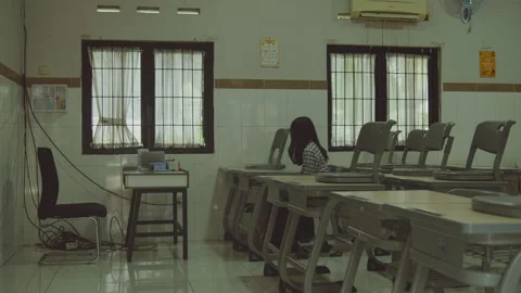 Person sitting alone in an empty classroom Stock Footage 281612065