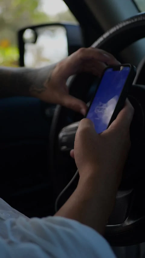 Person sitting in car using smartphone with blank blue screen... Stock Footage 324632440