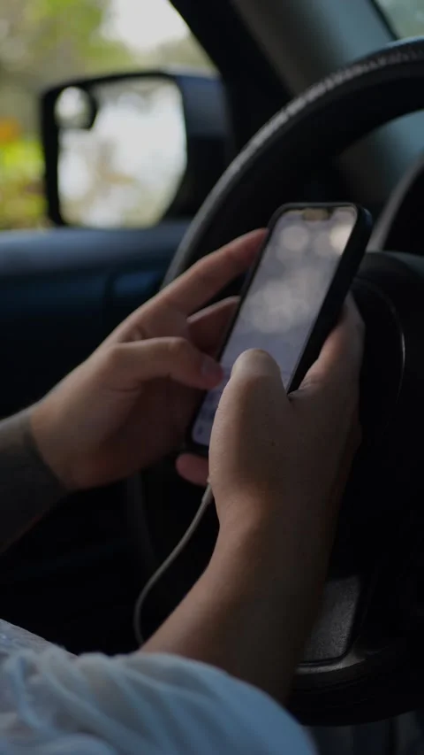 Person sitting in car using smartphone, hands typing on screen near... Stock Footage 324632443