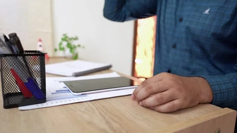 Person sitting at a desk with a tablet, documents, and stationery Stock Footage 318056872