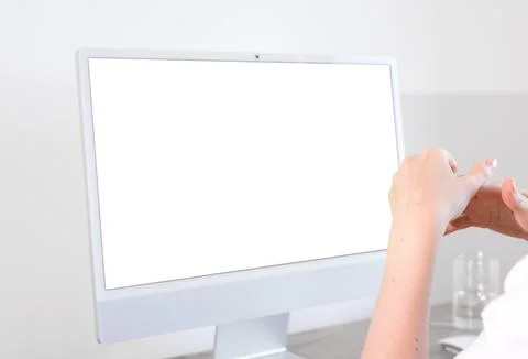Person sitting at desktop computer with blank screen mockup on wooden offic.. Foto stock