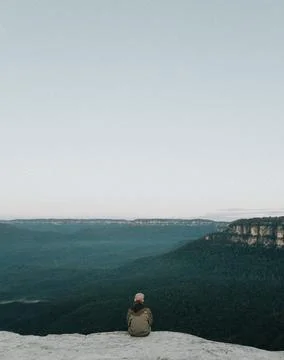 Person Sitting on Rock While Sight Seeing Stock Photos