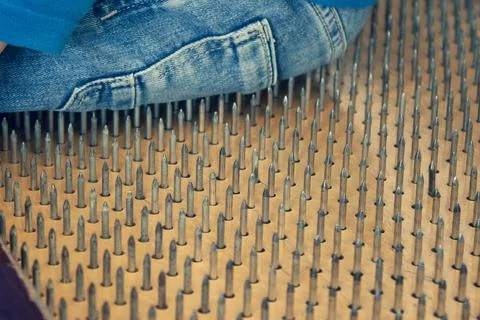 Person is sitting on sharp nails, close up 스톡 사진