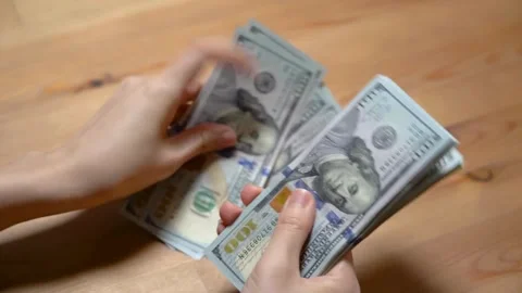 Person sitting at the table, counts earned money, fixing profits. Save up b.. Stock Footage 266470965
