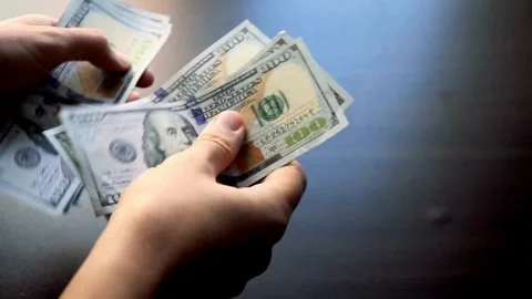 Person sitting at the table, counts earned money, fixing profits. Save up b.. Stock Footage 266471533