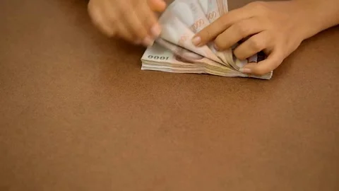 Person sitting at the table, counts earned money, fixing profits. Save up b.. Stock Footage 266471848