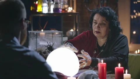 A person sitting at a table in front of a cake Stockbeeldmateriaal 136890212