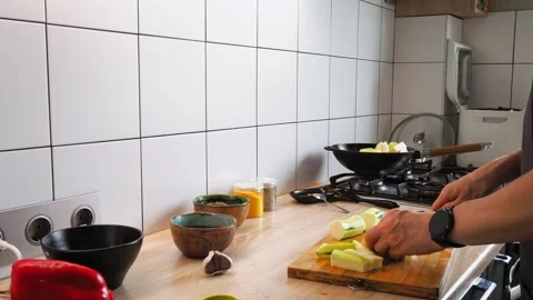 A person skillfully chops fresh vegetables in a contemporary kitchen setting Video stock 316481055