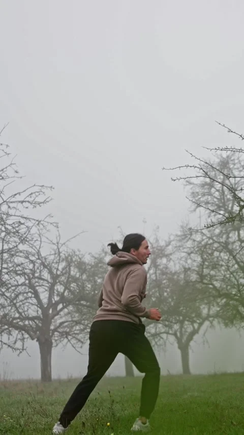 A person skillfully executing a dynamic and energetic kick within a misty Stock Footage 308370790