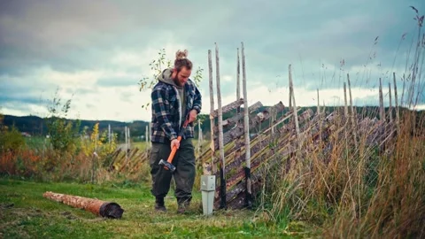 Person With Sledgehammer Constructing A Traditional Norwegian Skigard Fence On Stock Footage 337404329