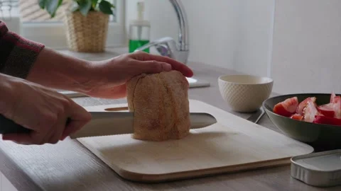 Person Slicing Bread and Spreading Cream Cheese in Kitchen Stock Footage 345834749