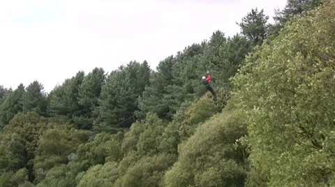 Person sliding down a long zip slide in a forest location Stock Footage 28666628