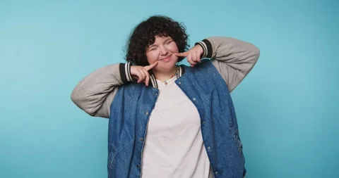 Person smiles and poses while playing with their hair in a bright room with.. Vídeo Stock 328247227