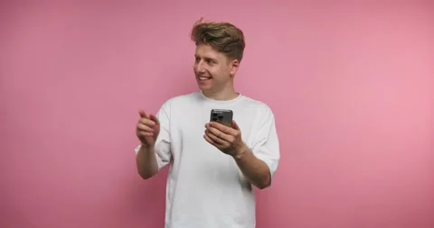Person smiles while using smartphone and shows excitement in playful moment.. Stock Footage 331990915