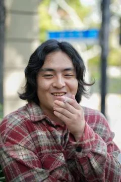 Person smiling while holding cigarette Stock Photos