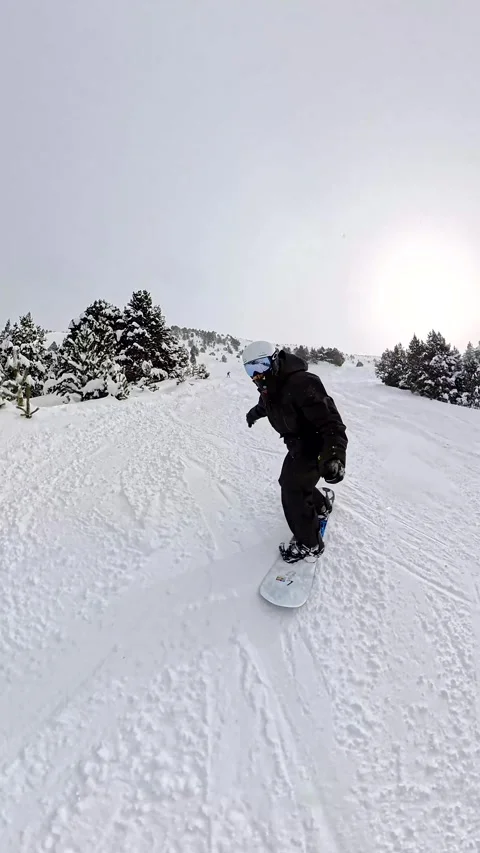 Person snowboarding down mountain slope in winter Stock Footage 340789727