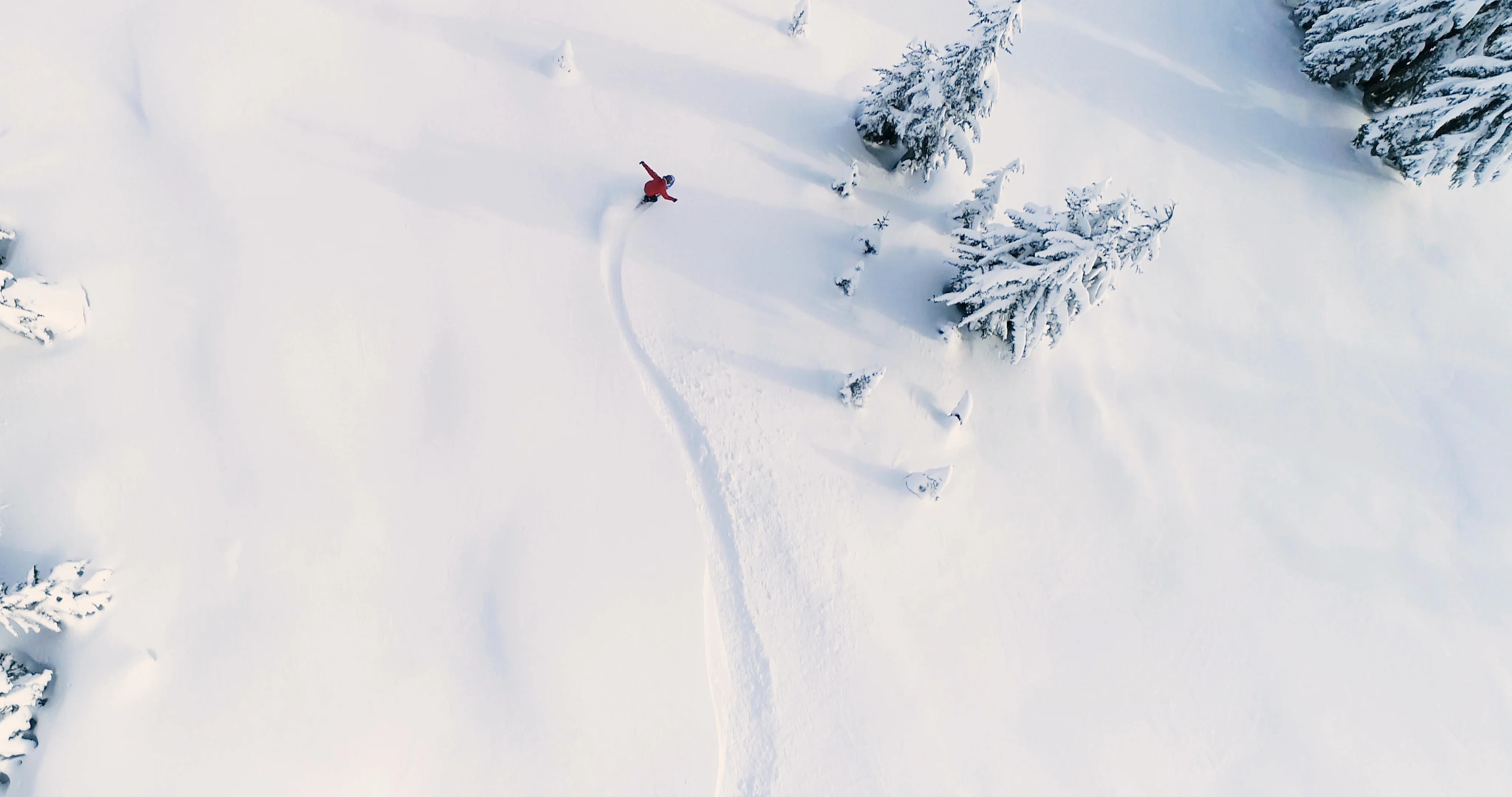 person snowboarding down slope