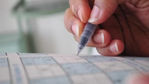 Person Solving a Sudoku Puzzle with a Pen Stock Footage 345188680