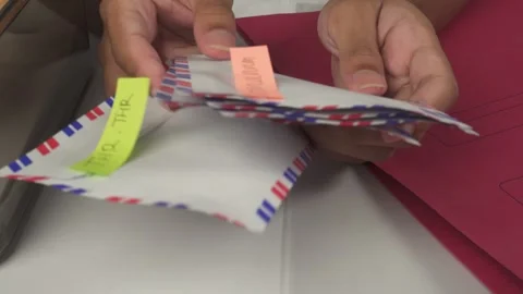 Person sorting envelopes on white table Stock Footage 276636953
