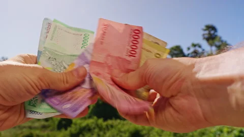 Person Sorting Indonesian Rupiah Banknotes by Value With Both Hands Outdoors, Cl Video stock 339206748