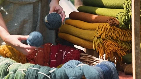 A person sorts various colored yarn from a woven basket in a medieval Видео 345031206