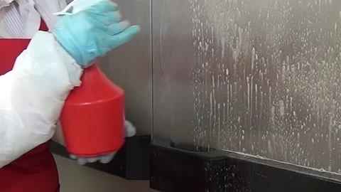 Person Spraying Cleaning Solution on a Stainless Steel Wall in Kitchen Stock Footage 320138301