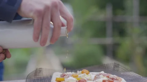 A person is spraying something on a pizza Stock Footage 297842827
