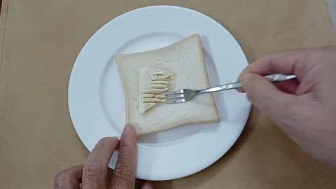 Person spreading cheese on slice of bread. Top view of sandwich with cheese. 스톡 동영상 260046103