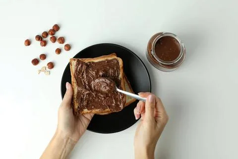 Person spreading chocolate spread on a slice of bread Stock Photos