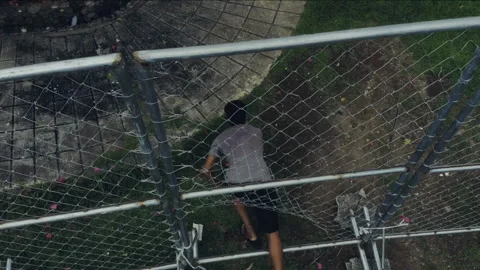 Person squeezing through a wire fence and running away 库存影片 334380928