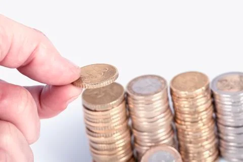 A person stack coins in columns isolated on white Stock Photos