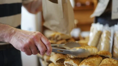 A person is standing in front of a table full of pastries Stock Footage 302468313